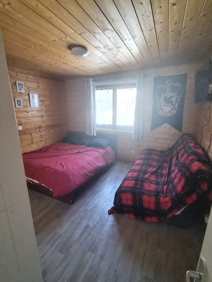 Chambre en bois avec lit double du chalet Tyson City