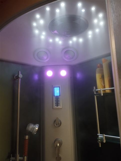 Douche hammam avec LED violettes, ciel étoilé et panneau de contrôle au chalet Tyson City