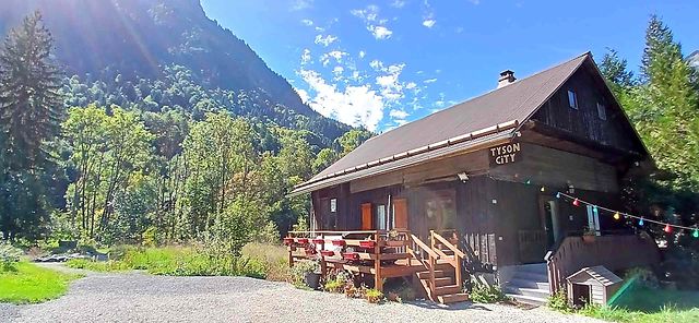 Chalet Tyson City à Entremont avec terrasse en bois et montagnes sous ciel bleu