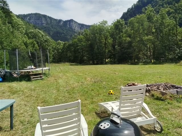 Jardin du chalet Tyson City avec transats et barbecue face aux montagnes des Glières