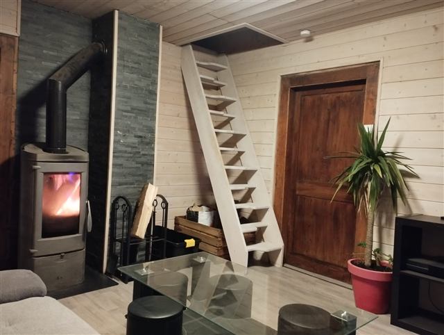 Poêle à bois allumé dans le salon cosy du chalet Tyson City